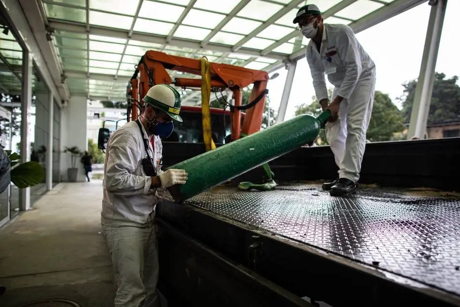 Homens carregam um cilindro de oxigênio no Hospital Universitário Getúlio Vargas em Manaus